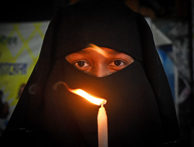 Muslimsk kvinna protesterar med ljus mot sexuellt våld