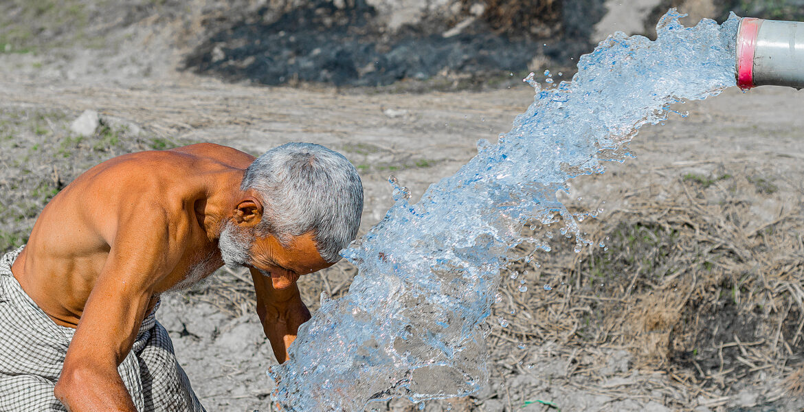En man på landsbygden i Pakistan söker välbehövlig svalka under värmeböljan.