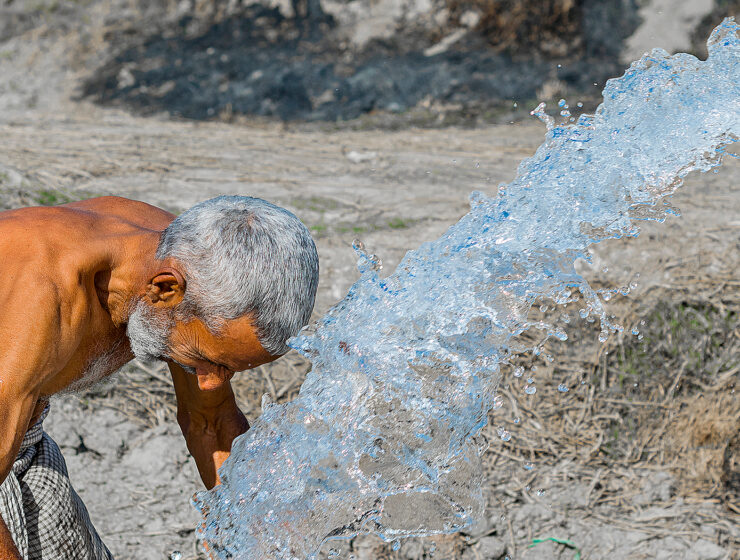 En man på landsbygden i Pakistan söker välbehövlig svalka under värmeböljan.