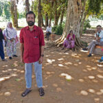 Indiska resenärer väntar under ett träd i Sri Lanka