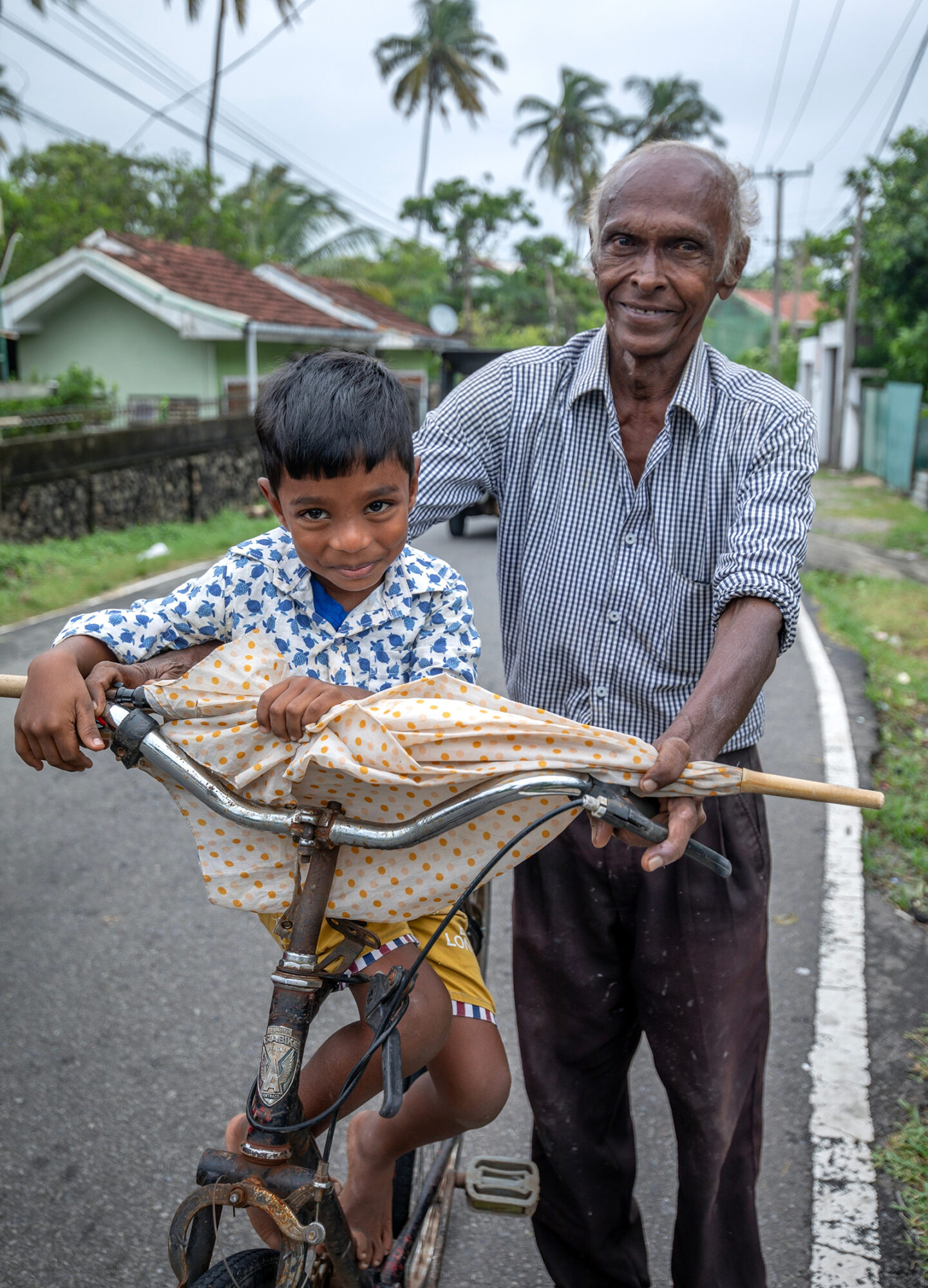 En man och hans barnbarn går vid St Sebastiyan Mawatha i Negombo efter att cyklonen Ditwah har bedarrat.